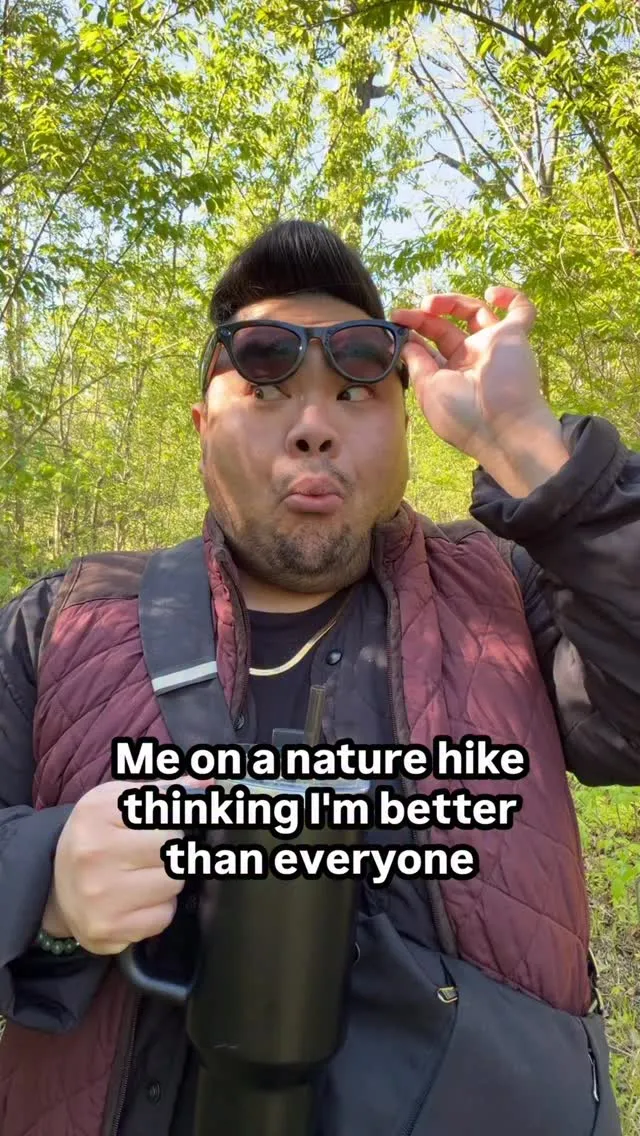 I lift Ray-Ban Meta glasses while hiking on a wooded trail.