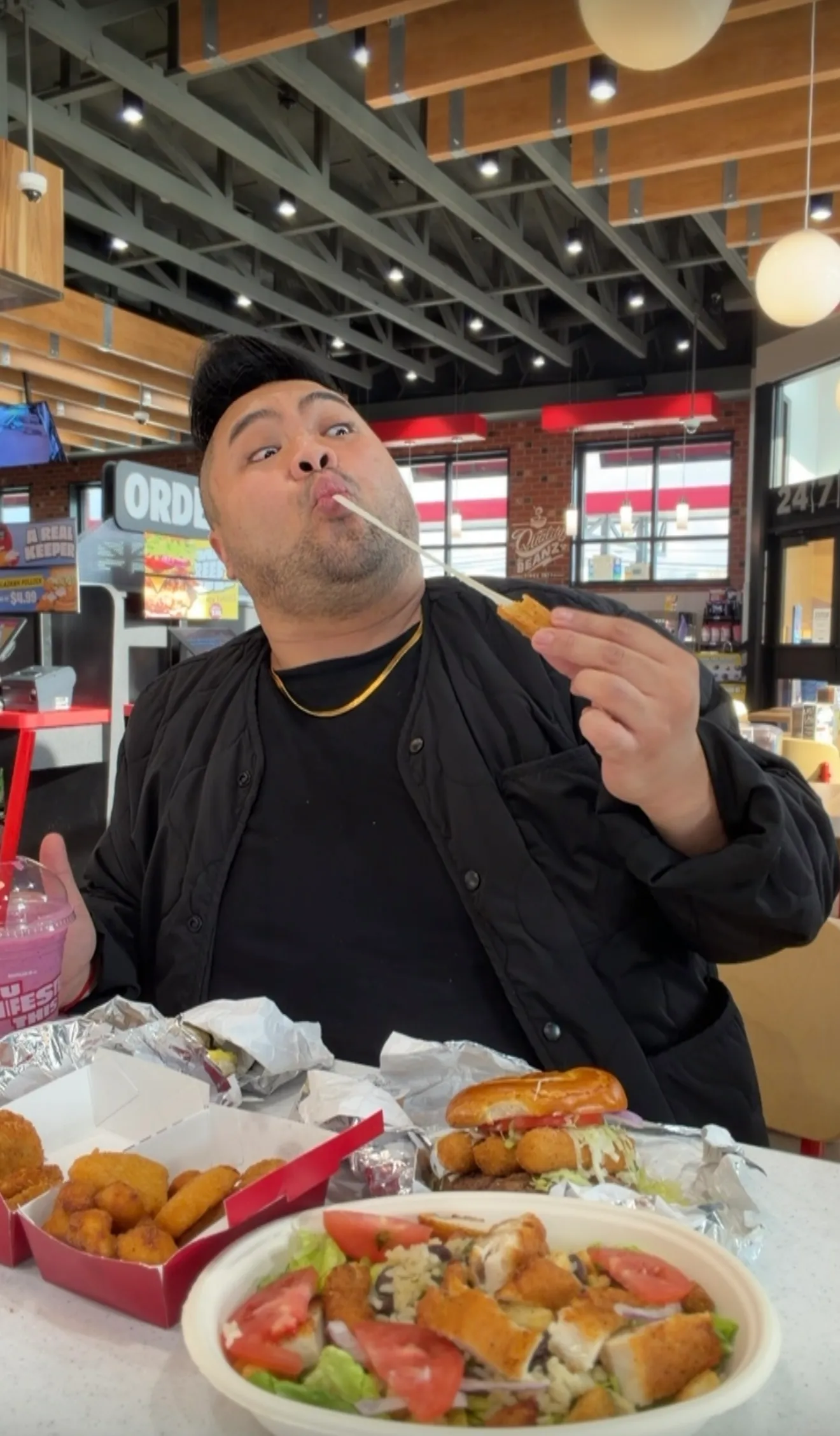 I stretch melted cheese from a sandwich behind a spread of Sheetz food.