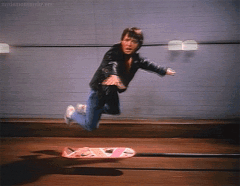 A person runs toward a skateboard, slips, and falls.