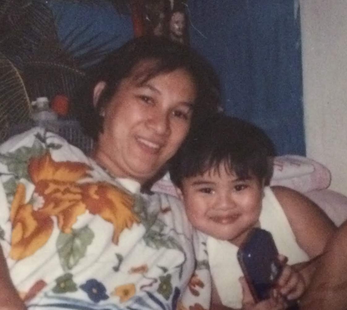 A childhood photo of RV Mendoza sitting beside his smiling mother.