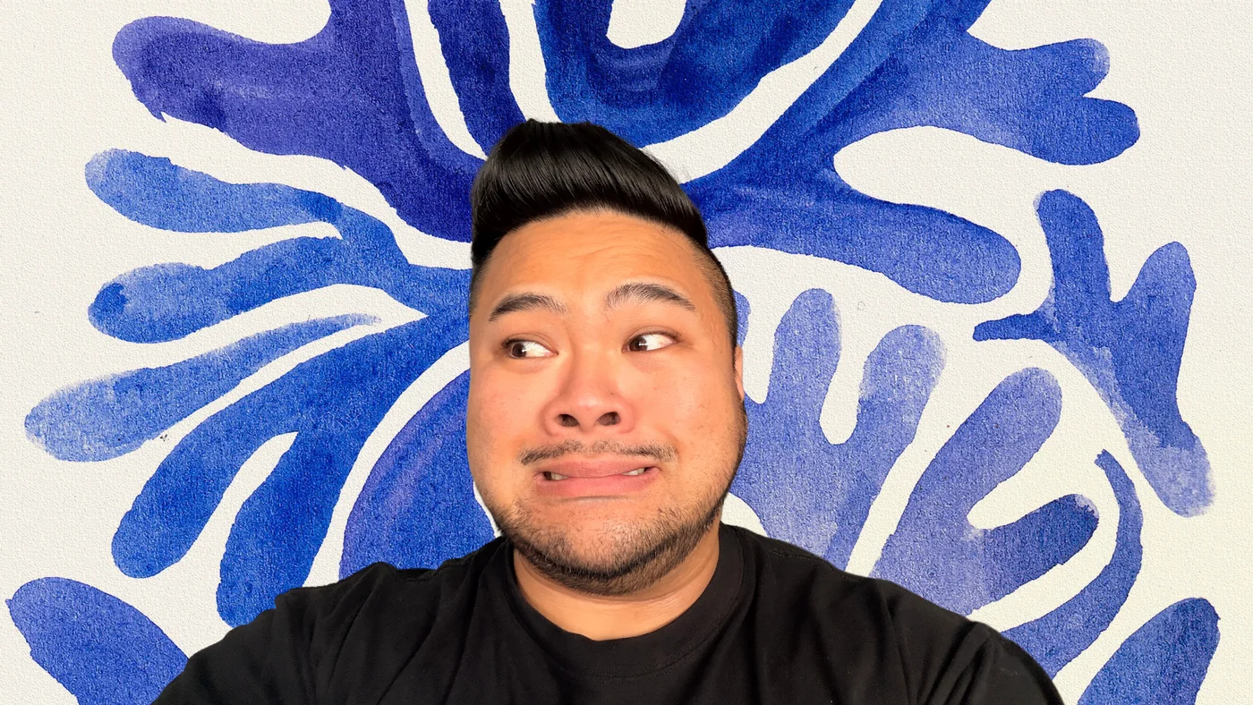RV Mendoza making a tense expression in front of a blue abstract pattern.