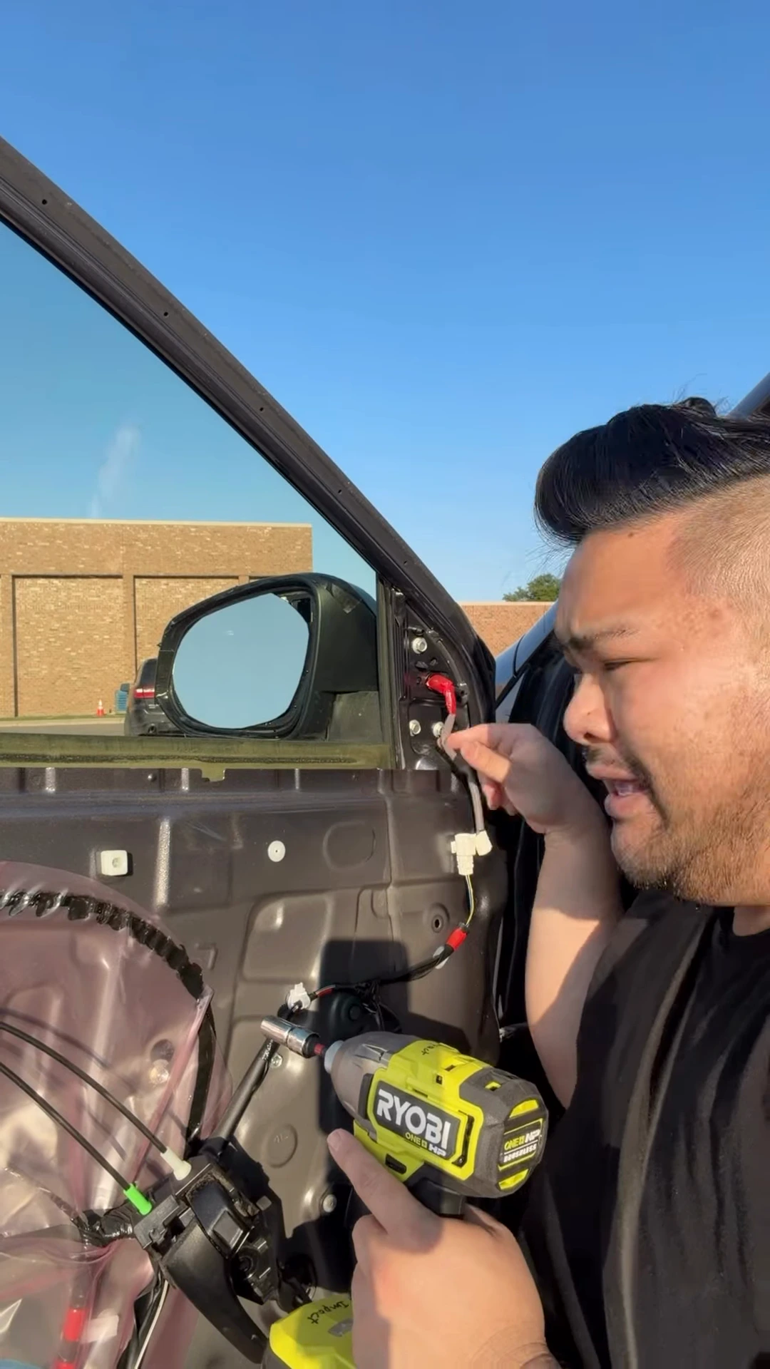 RV Mendoza uses a RYOBI power tool inside the exposed driver’s-side door.